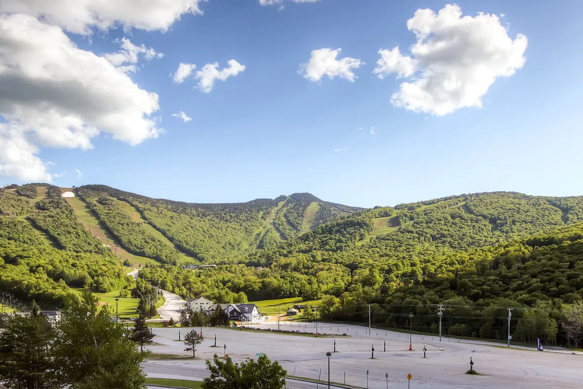 A panoramic view of a stunning mountain range under a clear sky, with an open, natural landscape in the foreground. The scene evokes feelings of serenity, expansive freedom, and the restorative power of nature—a key component of the retreat’s tranquil setting.